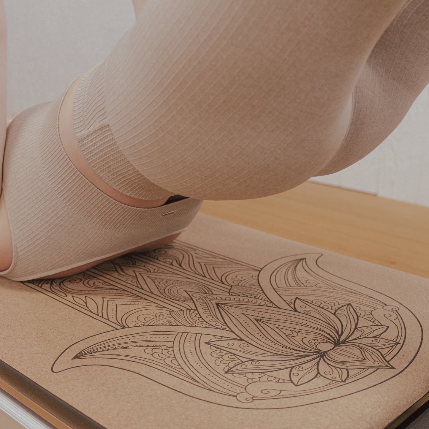 Woman performing bridge on hamsa hand cork and natural rubber Pilates reformer mat.